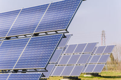 View of solar panels on grass against blue sky