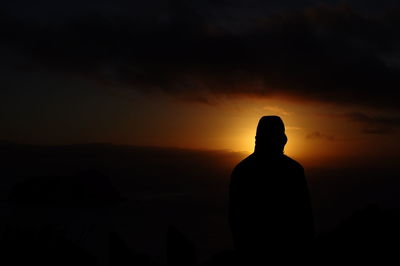 Silhouette man against orange sky during sunset