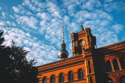 Low angle view of buildings against cloudy sky