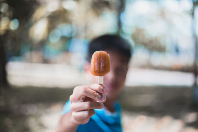 Man holding popsicle outdoors