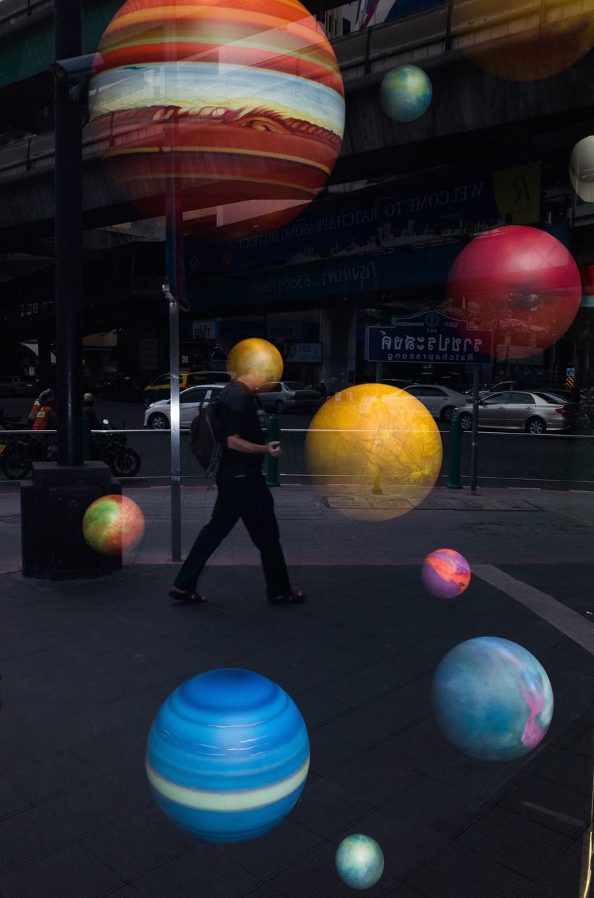 balloon, sphere, ball, full length, one person, real people, moon, illuminated, indoors, multi colored, yellow, men, standing, clown, helium balloon, architecture, day, astronomy, people