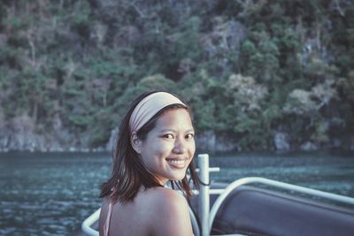 Portrait of smiling young woman on boat in sea