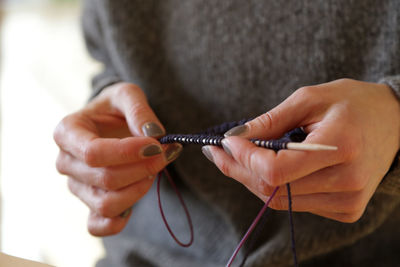 Midsection of woman knitting