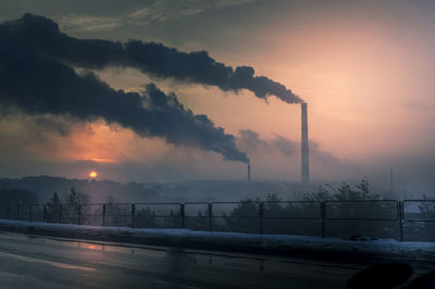 Smoke emitting from chimney against sky during winter