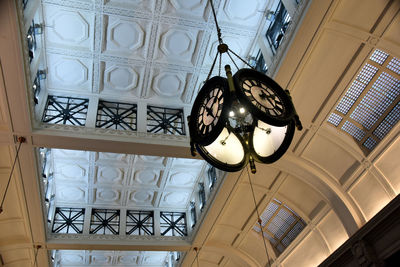 Low angle view of illuminated chandelier hanging on ceiling of building