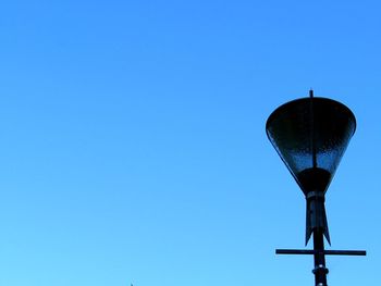 Low angle view of communications tower against clear blue sky