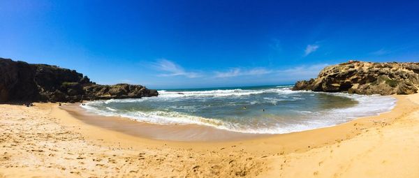 Scenic view of beach against blue sky