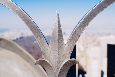 Cropped image of metallic fence against sky