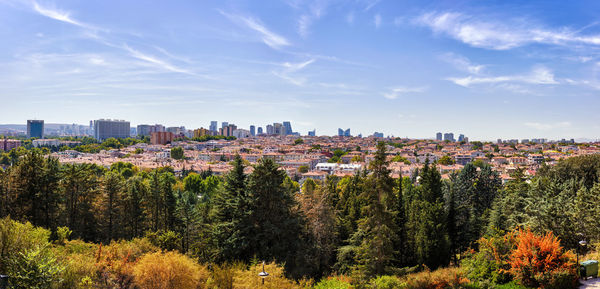 Panoramic view of trees and buildings against sky