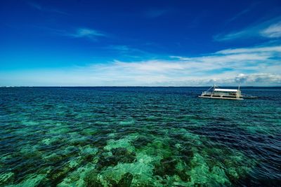 Scenic view of sea against blue sky