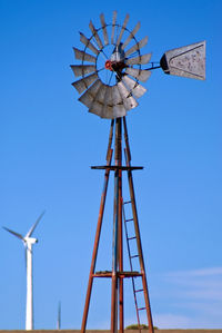 Low angle view of windmill against clear blue sky