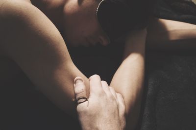 Cropped hand holding arm at home