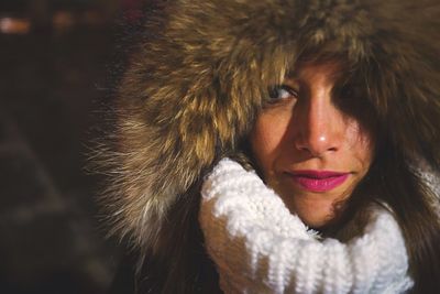 Close-up of smiling young woman wearing fur hood