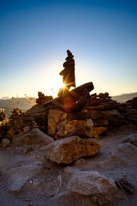 Stack of rocks against sky during sunset