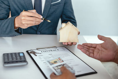 Midsection of man holding paper at table