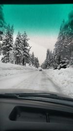 Cars on road against cloudy sky