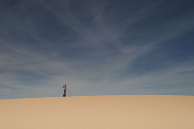 Man standing in desert against sky