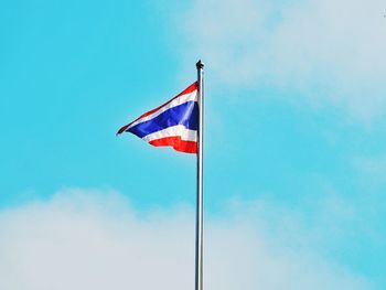 Low angle view of flag against blue sky
