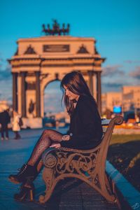 Woman sitting in front of building