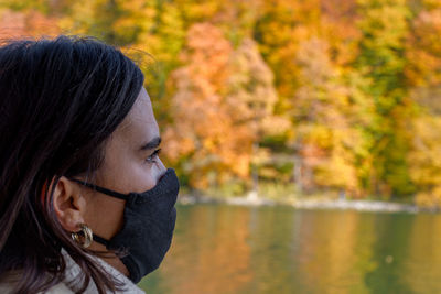 Woman wearing black face mask on a tourist boat at plitvice lakes national park in croatia