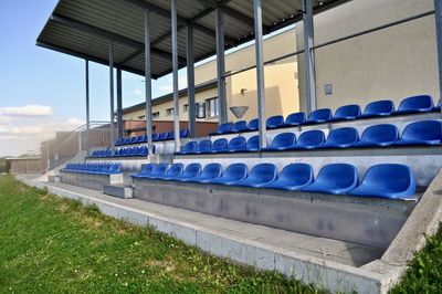 Empty seats in row against blue sky