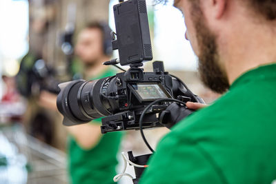 Midsection of man holding camera