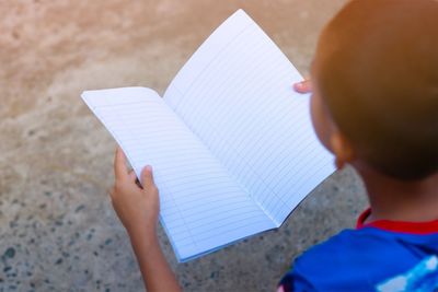 High angle view of boy reading book