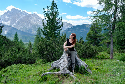 Woman in forest against sky