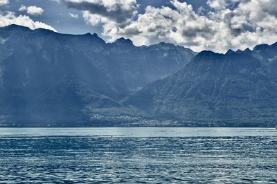 Scenic view of sea and mountains against sky