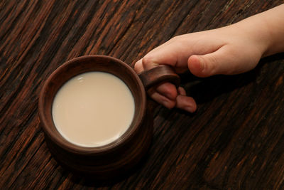 High angle view of hand holding bowl on table