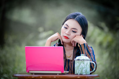 Portrait of young woman using digital tablet