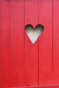 Close-up of heart shape on red door