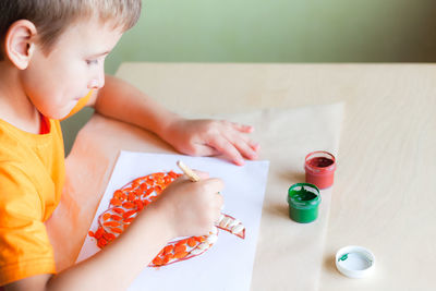 High angle view of baby boy holding table