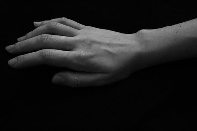 Close-up of hand over black background
