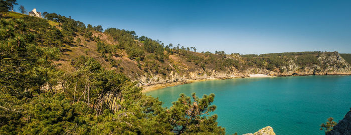 Scenic view of bay against clear blue sky