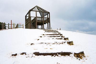 Low angle view of snow covered field against sky