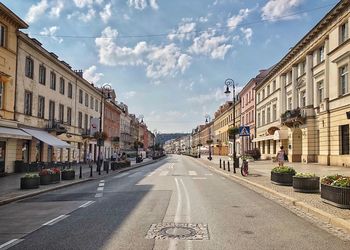 Empty road amidst buildings against sky