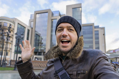 Portrait of man standing against buildings