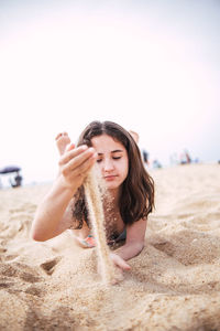 Little girl playing with sand on the beach