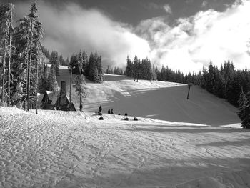 People on snow covered field against sky