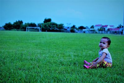 Girl sitting on grassy field