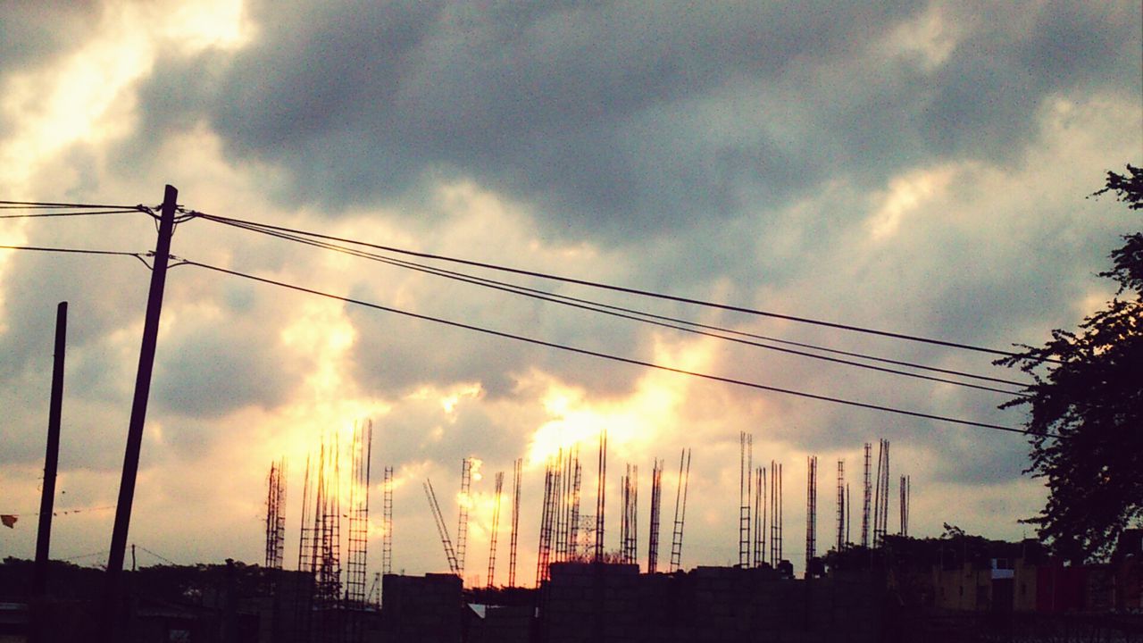 power line, sky, low angle view, silhouette, electricity pylon, cable, cloud - sky, sunset, electricity, connection, power supply, building exterior, built structure, architecture, cloudy, cloud, power cable, fuel and power generation, technology, dusk