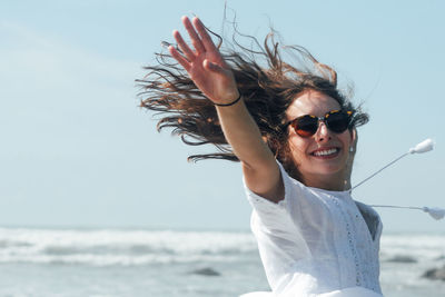 Portrait of smiling young woman against sea