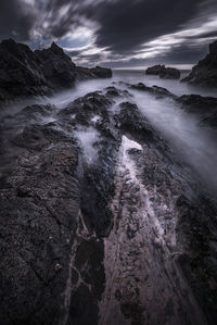 Scenic view of waterfall against sky