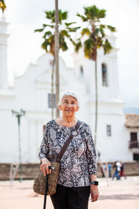 Senior adult woman at the central square in the city of guaduas. senior travel concept.