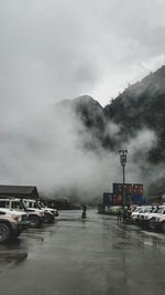 Cars on road against sky in city