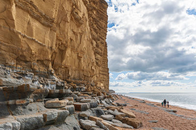 Rock formation on beach against sky