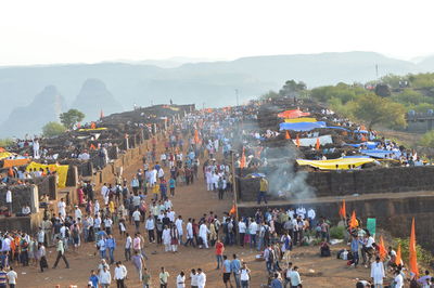 Crowd at market by mountains against clear sky