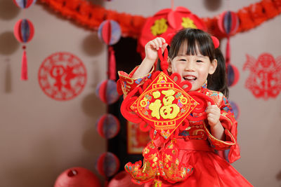 Young chinese girl with traditional dressing up holding  greeting card celebrate chinese new year