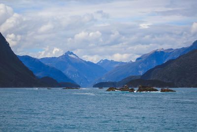 Scenic view of sea and mountains against sky